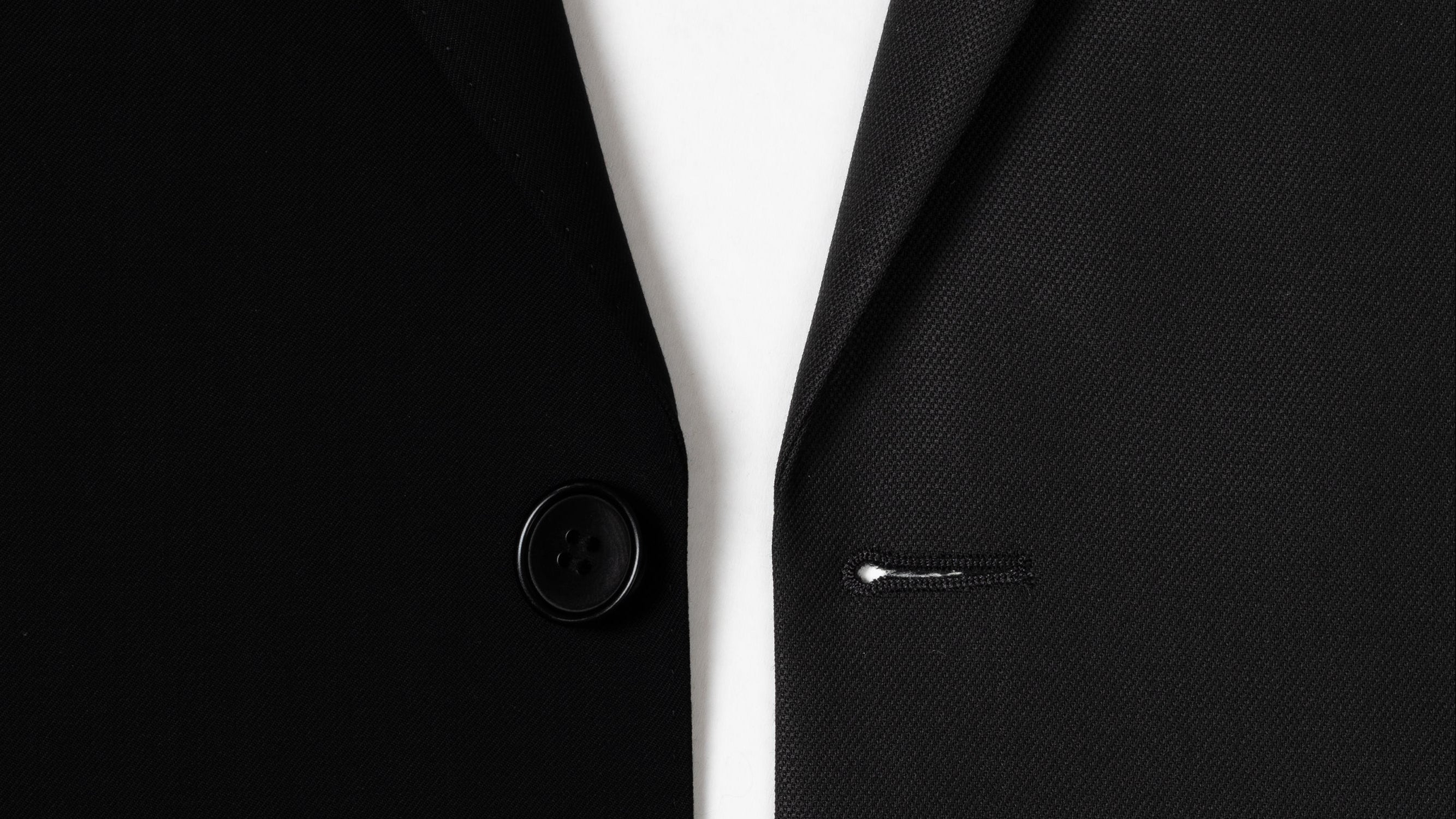 Close-up of a black suit jacket with buttons on a white background